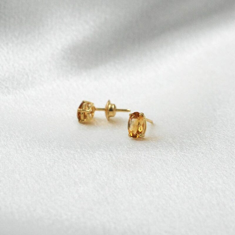 Aros minimalistas de oro 18k con citrino natural ovalado, diseño sutil.