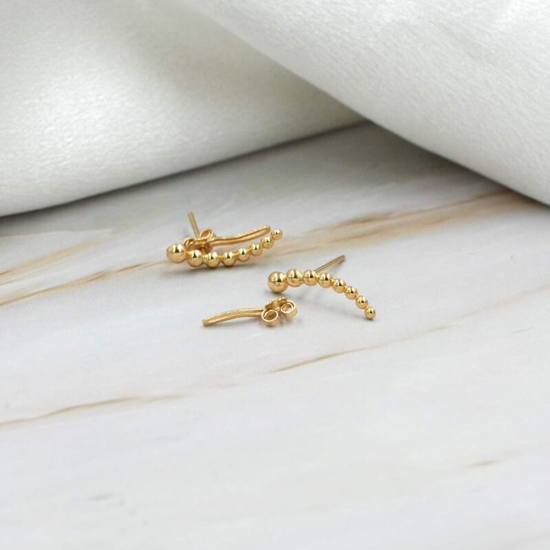 Earcuff minimalista de oro 18k con bolitas, ideal para combinar y usar a diario.