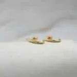 Detalle de aros de oro 18k con circón, diseño moderno y elegante