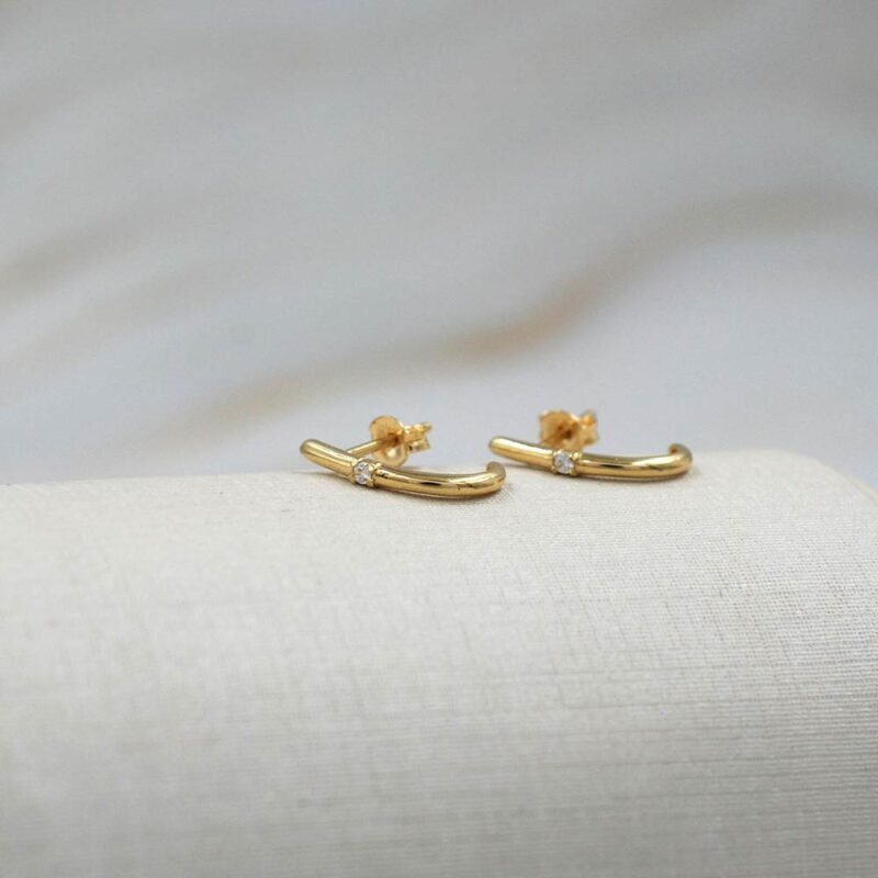 Detalle de aros de oro 18k con circón, diseño moderno y elegante