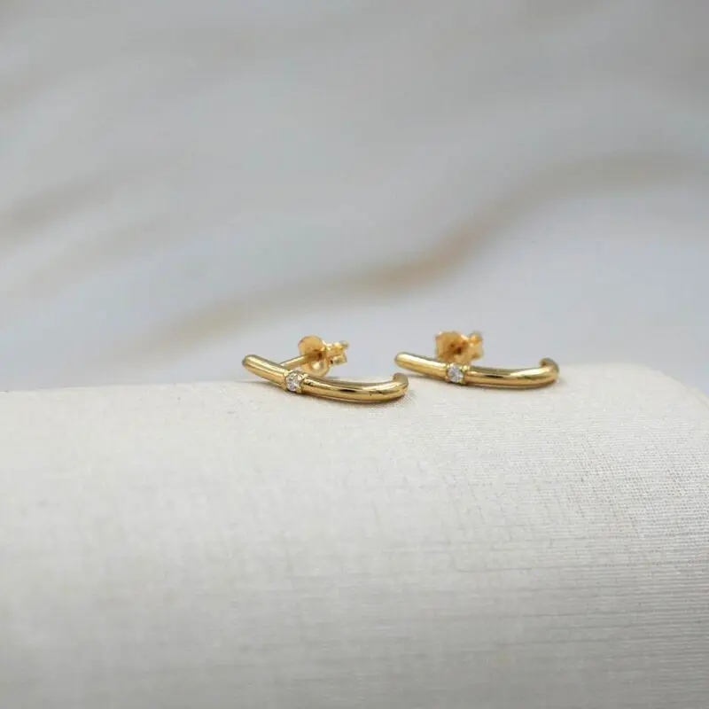 Detalle de aros de oro 18k con circón, diseño moderno y elegante