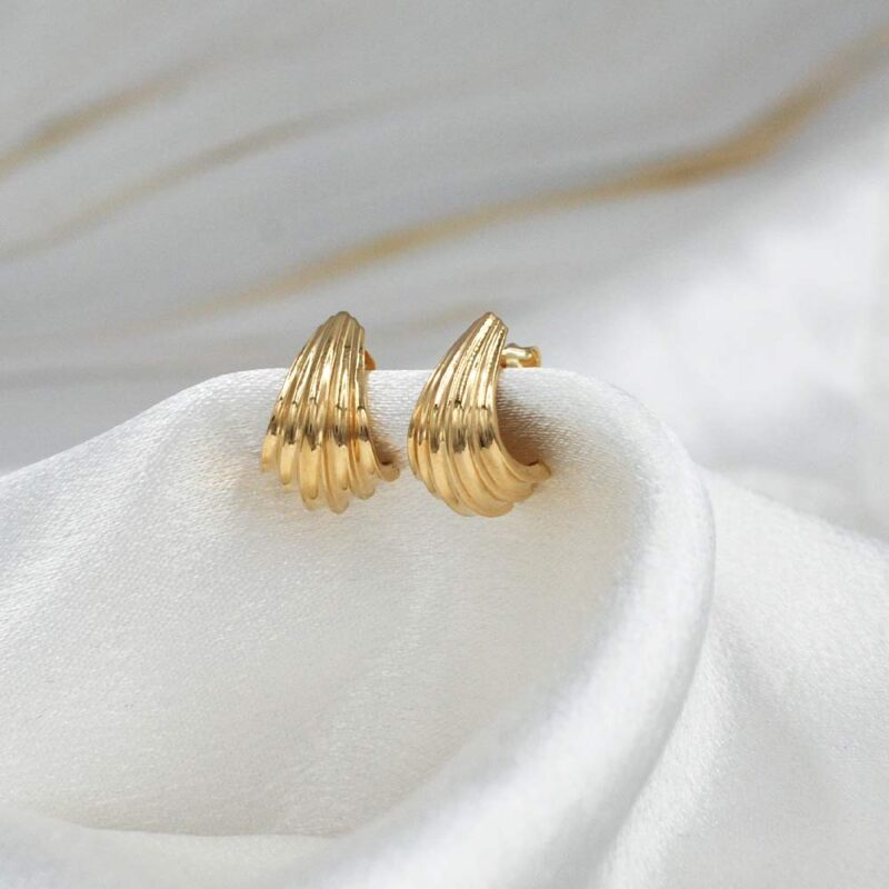 Aros Serena de oro 18k para mujer, diseño moderno de líneas curvas usado en la oreja.