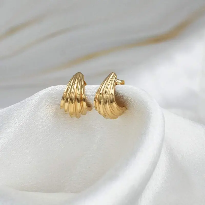 Aros Serena de oro 18k para mujer, diseño moderno de líneas curvas usado en la oreja.
