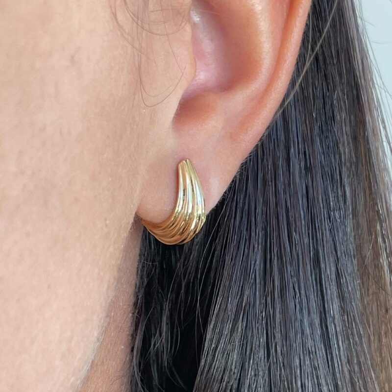 Aro Serena en oro amarillo 18k, línea curva pulida que se ajusta al lóbulo.