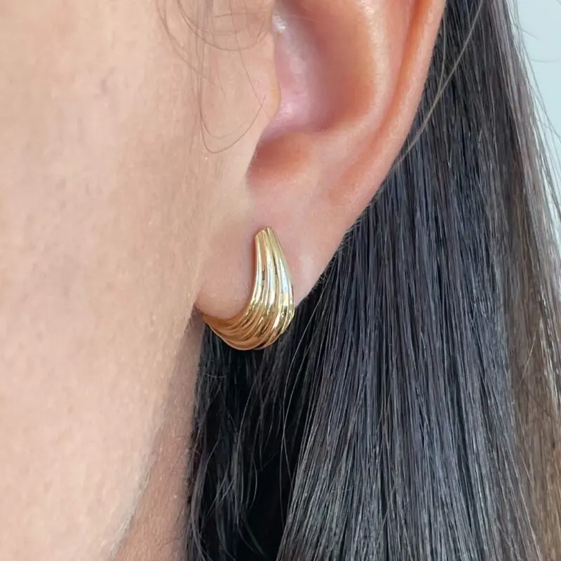 Aro Serena en oro amarillo 18k, línea curva pulida que se ajusta al lóbulo.