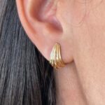 Aros macizos de oro 18k con diseño curvo, joya fina y elegante para mujer.