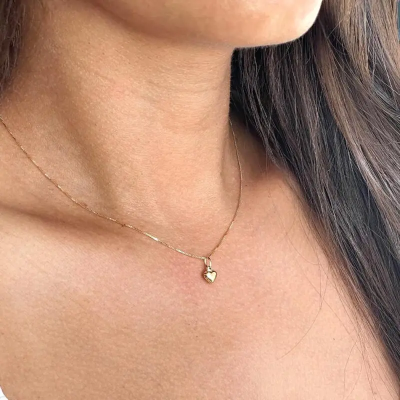 Conjunto Corazón Mini oro 18k usado en el cuello, estilo femenino y elegante.