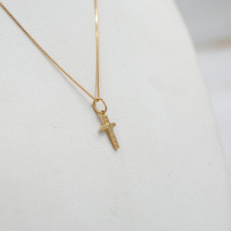 onjunto de joyería fina en oro 18k con colgante cruz brillante.
