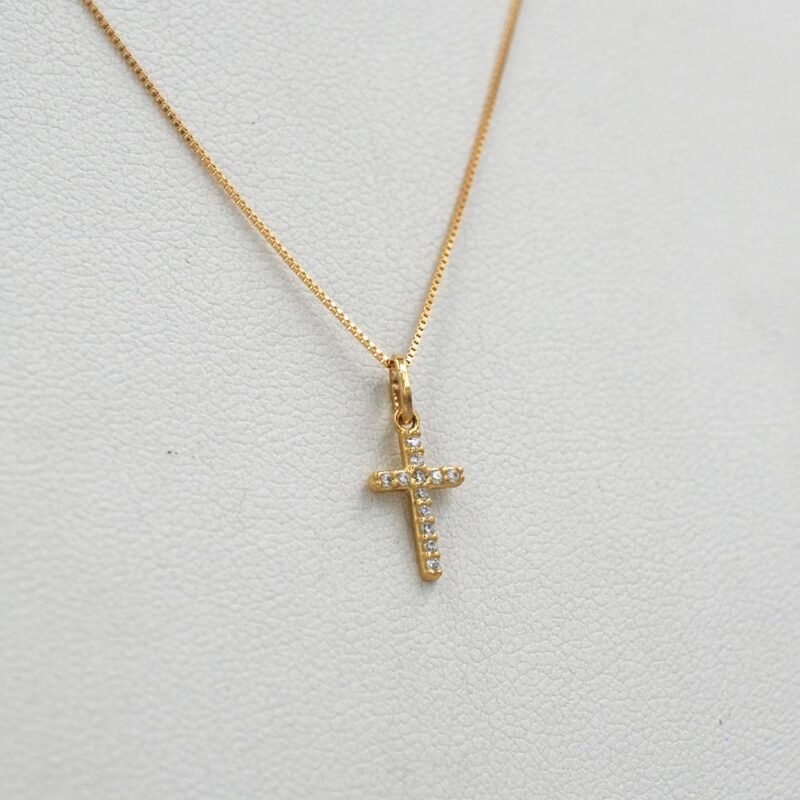 Colgante de cruz en oro amarillo 18k con circones brillantes.