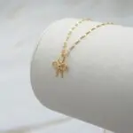 Conjunto de cadena y colgante lazo en oro 18k, joya fina para uso diario.