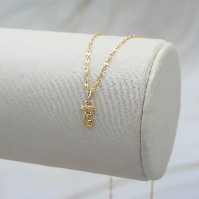 Dije de llave en oro amarillo 18k colgando en cadena fina